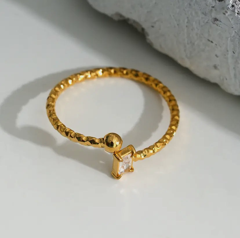 Gouden spiraalring met rechthoekige strass en bolletje