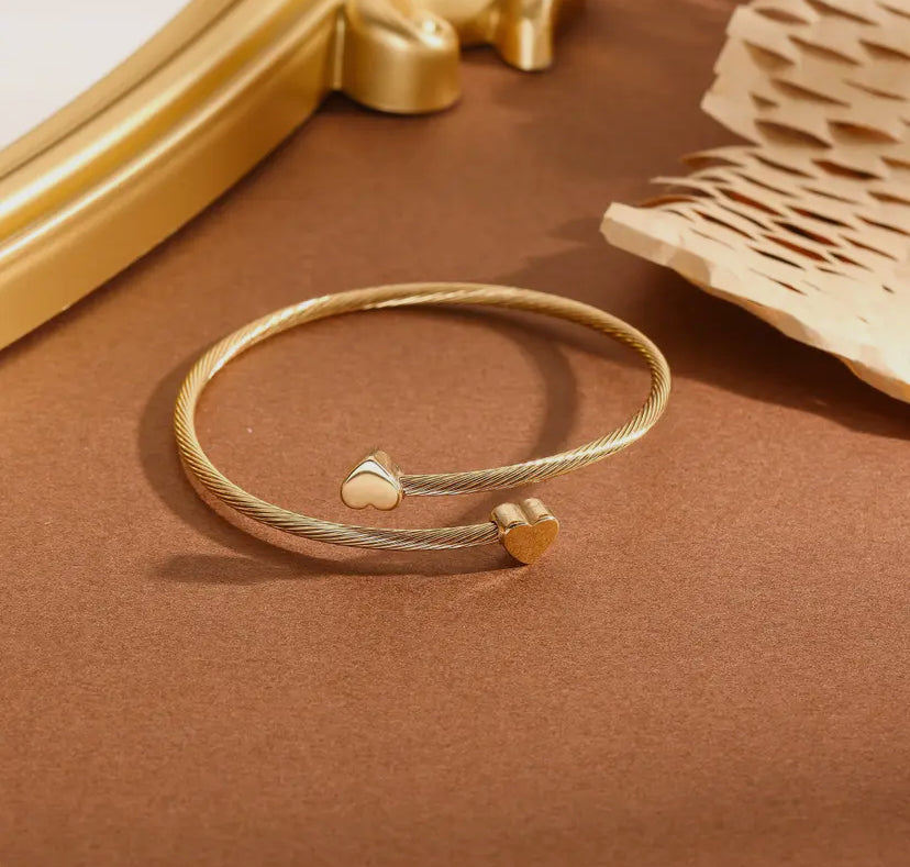 Gouden gevlochten armband met hartjes op gouden spikes